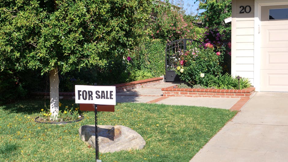 Home exterior with a professionally designed for-sale sign on a well-manicured lawn
